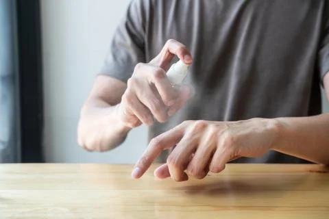 Image of Man using alcohol spray to hands washing with eliminate bacteria and Stock Photos