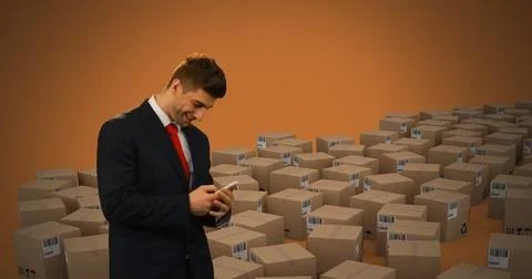 Image of man using smartphone with stacks of boxes on orange background 写真素材