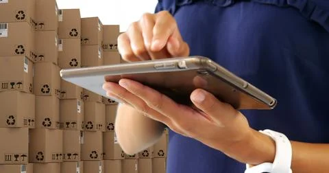 Image of man using tablet with stacks of boxes on white background Foto stock