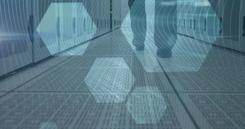 Image of man walking in tech room with computer servers with hexagons Stock Photos