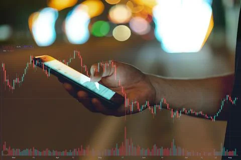 Image of a man's hand using his phone to check the stock exchange Stock Photos