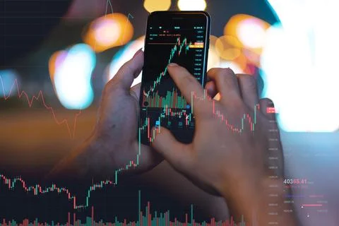 Image of a man's hand using his phone to check the stock exchange Stock Photos