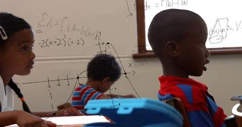 Image of math formulas over african american children learning at school 스톡 사진