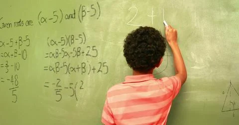 Image of math formulas over back view of biracial boy writing on black board Stock Photos