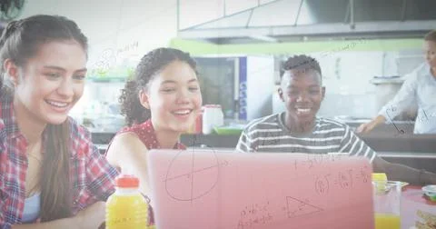 Image of mathematical equations over school children using laptop in classroom Foto stock
