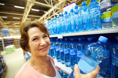 Image of mature customer holds bottle of pure water Stock Photos