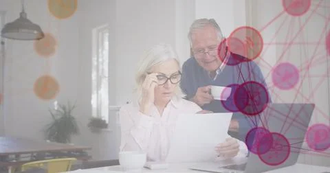 Image of media icons over senior caucasian couple using laptop Foto stock