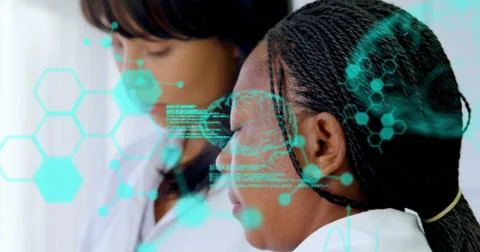 Image of medical data processing over two diverse female scientists working at Foto stock