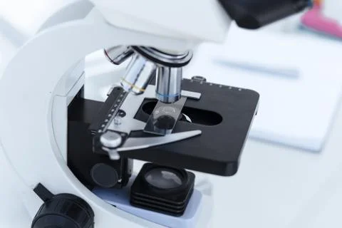 Image of a microscope with a sample on a table in the laboratory. Stock Photos