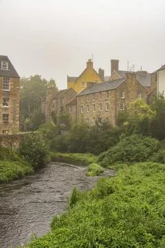 Image of a misty river surrounded by historic brick buildings and lush greenery, Fotos de archivo