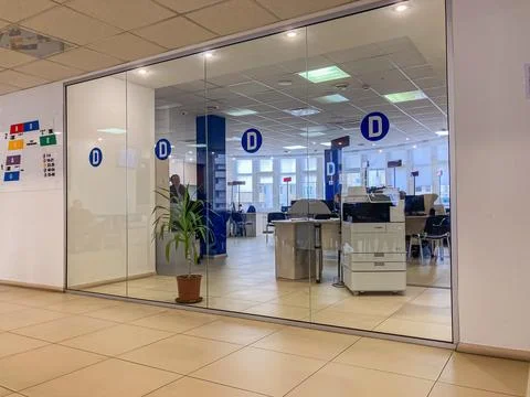 Image of a modern office room through a glass window, with a D direction sign Stock Photos