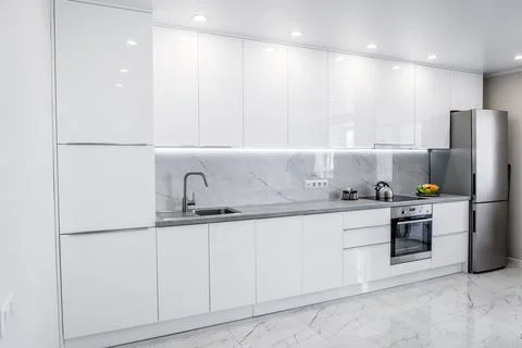Image of modern white kitchen with many cabinets and appliances Stock Photos