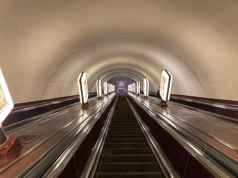An image of a moving escalator with reflective surface, handrails, and lighti 写真素材