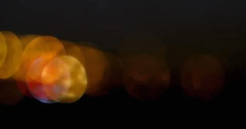 Image of moving spots of yellow light on black background 4k Stock Photos