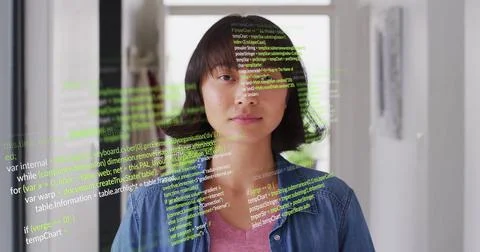 Image of multicolored computer language over asian woman standing at home Foto stock
