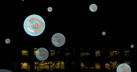 Image of multiple graph icons over aerial view of modern building against night Fotos de archivo