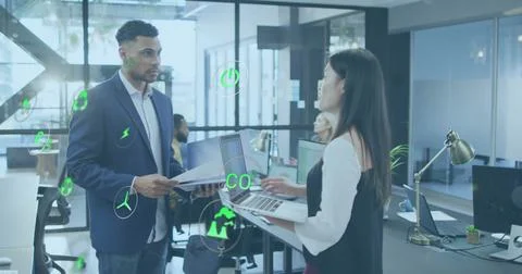 Image of multiple icons over diverse coworkers standing and discussing reports Stock Photos