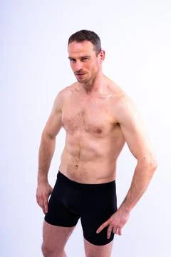 Image of muscle man posing in studio, dark white red background Stock Photos