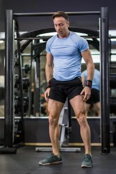 Image of a muscular man doing exercises at the gym. Stock Photos