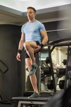 Image of a muscular man doing high knees exercises at the gym. Stock Photos