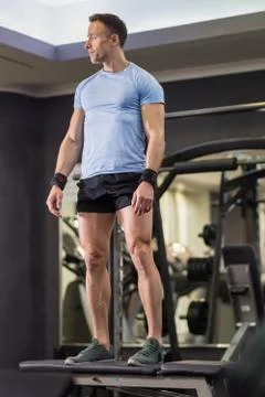 Image of a muscular man doing high knees exercises at the gym. Stock Photos