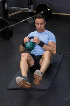 Image of a muscular man using kettlebell in exercise at the gym. Stock Photos