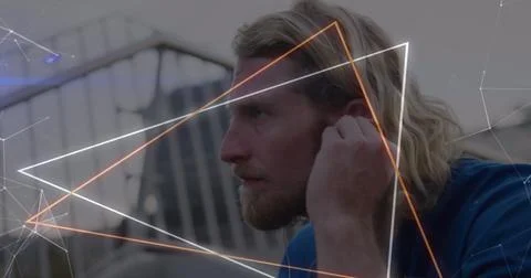 Image of neon triangular shapes over close up of caucasian man wearing earp.. 库存照片
