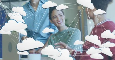 Image of network of cloud icon over diverse colleagues discussing together at Stock Photos