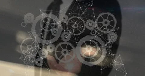 Image of network of connections with cogs over caucasian businessman Foto stock