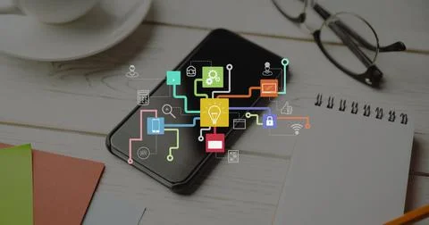 Image of network of icons over smartphone on desk Stock Photos