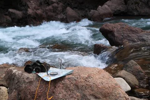 An image of old binoculars and a compass. Stock Photos