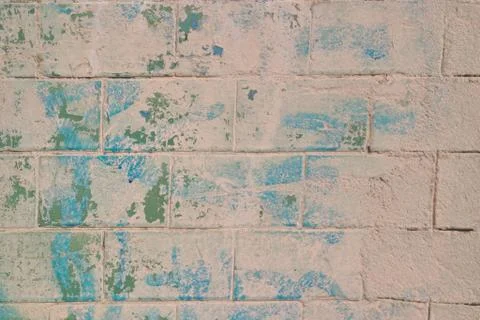 Image of an old brick wall with peeling green paint. Stock Photos