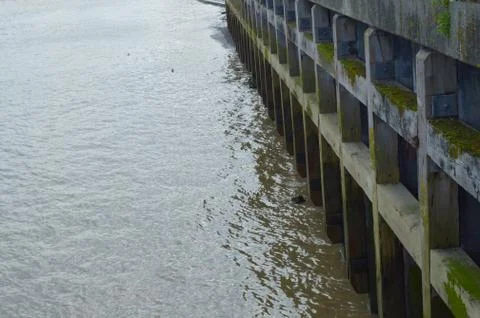 Image of old foundation of the docks with muddy thames river Stock Photos