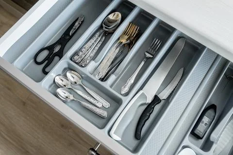 Image of open drawer with kitchen utensils, including forks, spoons, scissors an Stock Photos