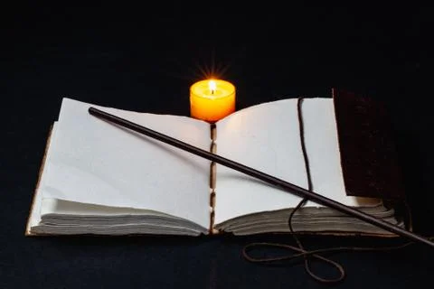Image of open magic book on the table in the dark room. Stock Photos