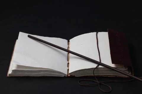 Image of open magic book on the table in the dark room. 库存照片