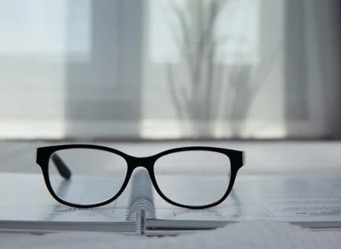 Image of an open notebook placed in bed with glasses .blurred background Stock Photos