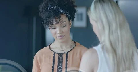 Image of padlock icons data processing over diverse businesswomen in office Stock Photos