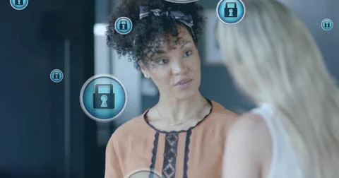 Image of padlock icons data processing over diverse businesswomen in office 写真素材