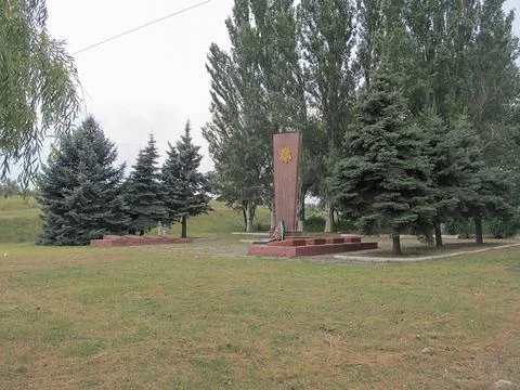 Image of a park with a tall, rectangular stone monument, possibly depicting a Stock Photos