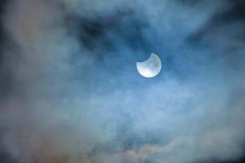 Image of a partial solar eclipse through veil clouds Fotos Stock