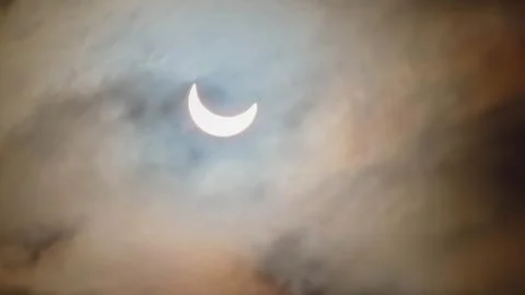 Image of a partial solar eclipse through veil clouds Fotos Stock