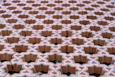 The image is of a patterned wall with a lot of holes in it Stock Photos