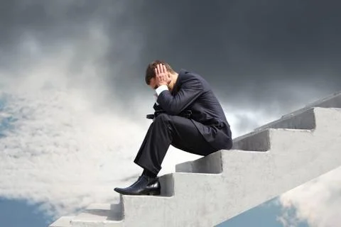 Image of pensive businessman sitting on stairs against thunderclouds Stock Photos