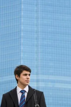Image of pensive guy looking aside on the background of modern office building Fotos de archivo