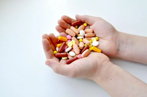 Image, photograph of the hands on which the medicinal tablets lie. Stock Photos