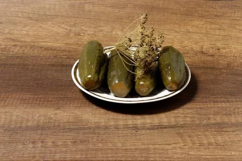 Image of pickled cucumbers on a plate on the table. Stock Photos