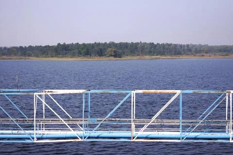 Image of a pipe line created in the middle of a blue lake Stock Photos