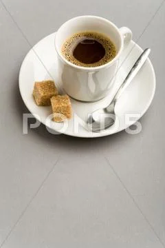 Image of porcelain cup with strong black coffee and two pieces of sugar on sauce Stock Photos