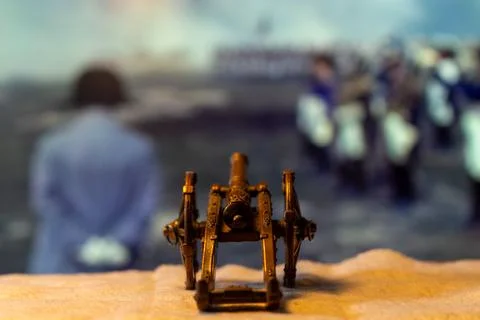 This image portrays a small antique weapon positioned in front of an indistinct Stock Photos